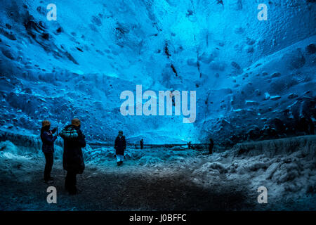 VATNAJOKUL, ICELAND: Shot of tourists inside the glacier. SUNLIGHT striking the inside of an ice cave transformed a normally blue frozen world into what looks like a golden glacier. Other images taken from inside the frozen formation range from the explorers, which include British tourists, keeping warm with a fire deep within the underground walls and exploring mighty snow pillars. Mountain guide Einar Runar Sigurdsson (47) from Oraefi, Iceland took the shots at the Vatnajokull Crystal Ice Cave, 50-miles from the nearest town Hofn, in the southeast of Iceland. Stock Photo