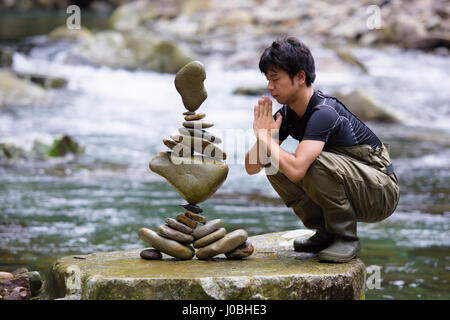 YASUKAWA VALLEY, JAPAN: INCREDIBLE pictures and video have captured the gravity-defying feats of one man who calls himself a rock balancing artist. The amazing footage shows increasingly larger rocks being balanced on smaller stones at near impossible angles. The mind-bending structures seem to abandon the laws of physics as the artist slowly but surely balances rocks in a seemingly unnatural manner. The footage was taken in Yasukawa Valley, Japan by local rock balancing artist Kokei Mikuni (30) from At Yuasa-Cho. Stock Photo