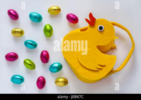 Felt chick with Easter eggs - choccy eggs solid milk chocolate eggs isolated on white background  - ready for Easter Stock Photo