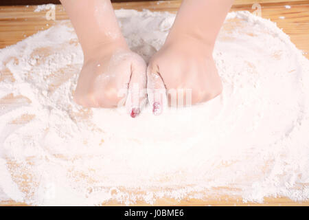 Close-up of woman hands kneading dough on wooden table. cooking and baking concept. Stock Photo