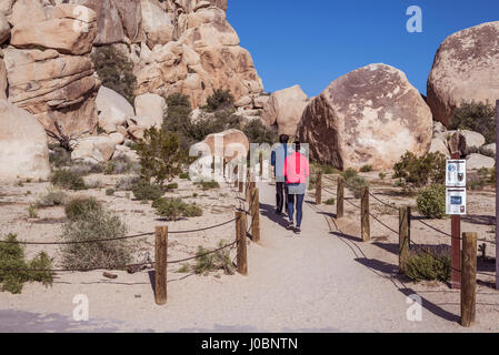 Two people at the trailhead for Hidden Valley.  Joshua Tree National Park, California, USA. Stock Photo