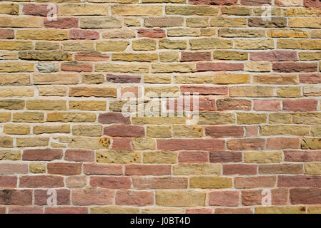 Warm coloured stone wall. Abstract pattern of old masonry on a small church at Chadkirk, Stockport, England. Stock Photo