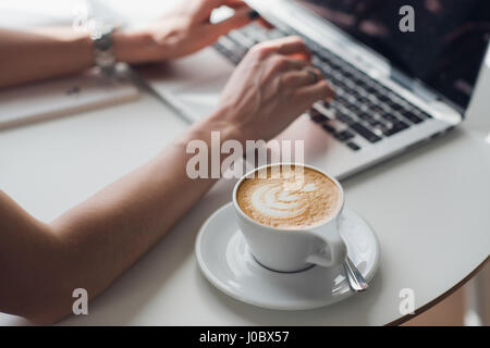 Hands multitasking woman working on laptop connecting wifi internet, businessman hand busy using laptop at office desk, finger typing on keyboard computer sitting at wooden table,work at home. Stock Photo