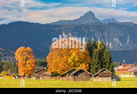 Wooden huts surrounded by colorful trees in autumn, Garmisch Partenkirchen, Upper Bavaria, Germany Stock Photo