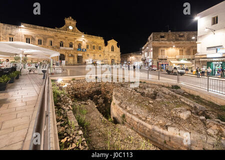 Night view of the Town Hall and ancient ruins in the medieval old town of Ostuni, Province of Brindisi, Apulia, Italy Stock Photo