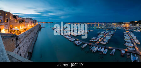 Dusk lights the harbor and the medieval old town of Otranto, Province of Lecce, Apulia, Italy Stock Photo