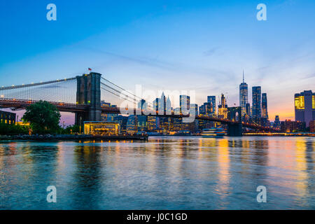 Brooklyn Bridge and Manhattan skyline at dusk, viewed from the East River, New York City, USA