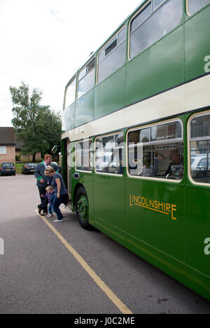 Green vintage 1955 Bristol Lodekka LD6B bus with Lincolnshire on the side with bus driver stood by the door and a woman and her child getting off Stock Photo