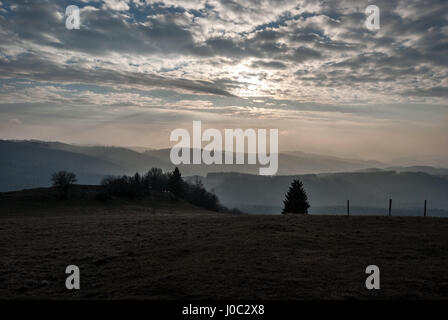 mountain meadow with trees on Ochodzita hill above Koniakow village in late autumn Silesian Beskids mountains in Poland with hills on the backgrounds  Stock Photo