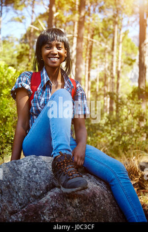 Portrait of young woman sitting on rock, Cape Town, South Africa Stock Photo