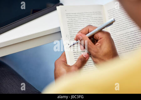 University student writing notes in book Stock Photo