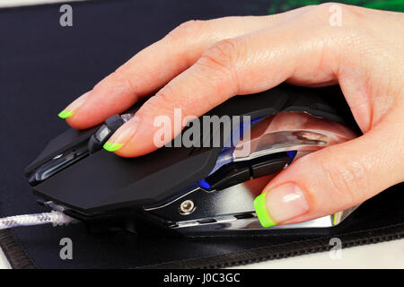 The female hand controls the modern game computer mouse Stock Photo