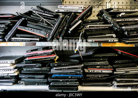 Pile of old, discarded laptops on shelf Stock Photo