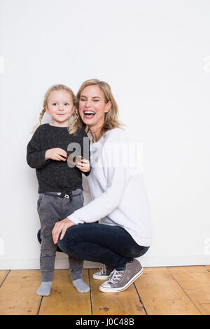 Portrait of mother and daughter, daughter holding pine cone Stock Photo