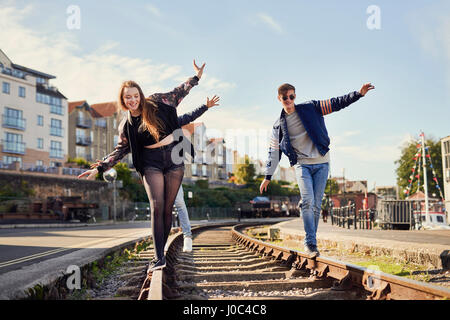 Three friends balancing on train track, Bristol, UK Stock Photo