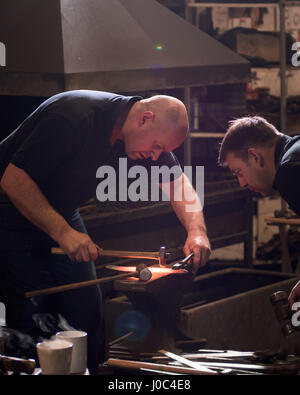 Farriers forging horseshoe on anvil Stock Photo