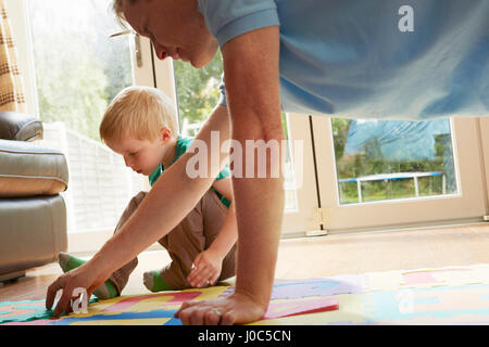 Boy and father playing with floor jigsaw puzzle Stock Photo