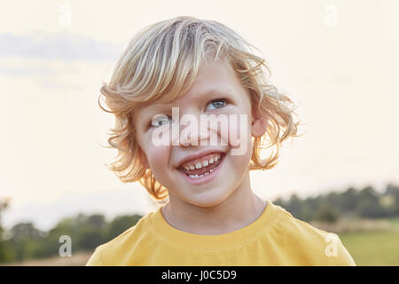 Portrait of blond-haired, blue-eyed boy on playing field Stock Photo