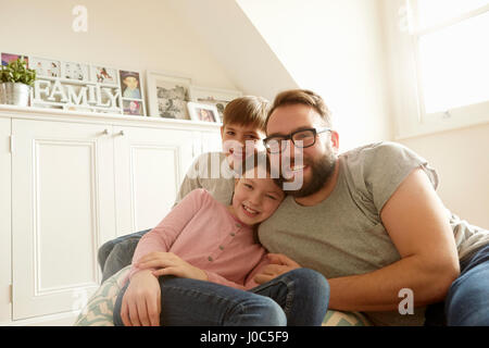 Portrait of mid adult man with son and daughter reclining on beanbag chair Stock Photo