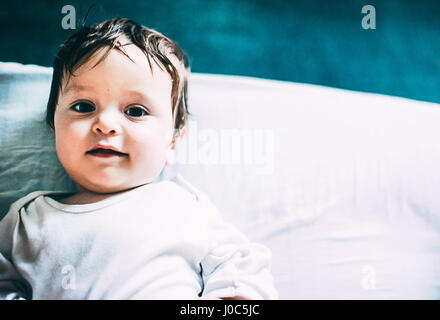 Portrait of baby boy lying in bed Stock Photo