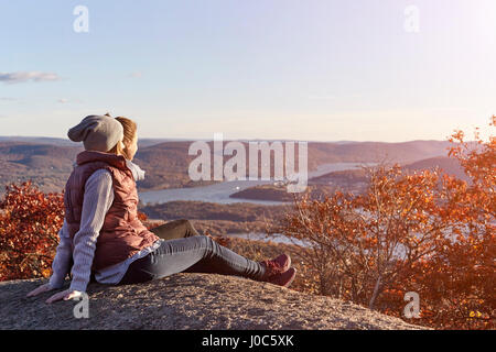 Two young women looking out over lake and hills, New York State, USA Stock Photo