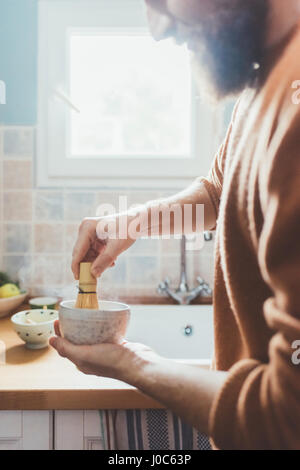 Cropped shot of man stirring bowl in kitchen Stock Photo