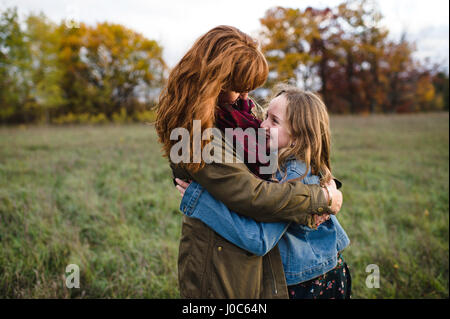 Mother and daughter hugging in meadow, Lakefield, Ontario, Canada Stock Photo