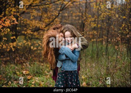 Mother and daughter hugging in wooded area, Lakefield, Ontario, Canada Stock Photo