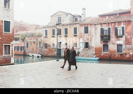 Couple strolling by canal waterfront, Venice, Italy Stock Photo