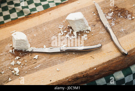 Soft farmers cheese with knives lay on wooden cutting desk, Amsterdam marketplace counters Stock Photo