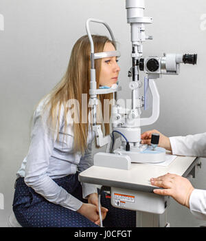 pretty young woman having her eyes examined by an eye doctor on a slit lamp Stock Photo