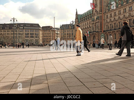 Pedestrians walking by the town hall in Rathausmarkt Square in Hamburg, Germany. Stock Photo