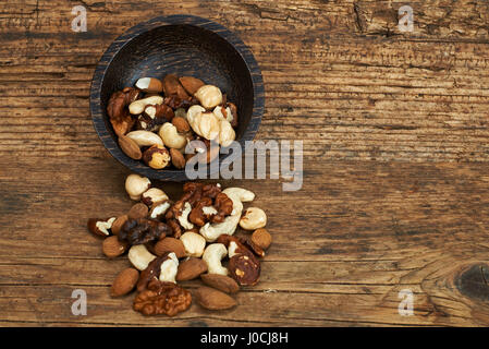 Bowl of mixed nuts on wooden table. Stock Photo