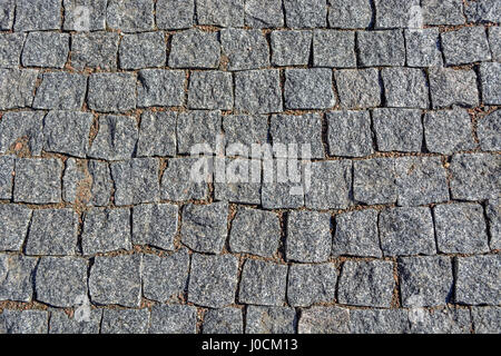 The image of a fragment of pavement from the gray paving stones to use as a background. Stock Photo