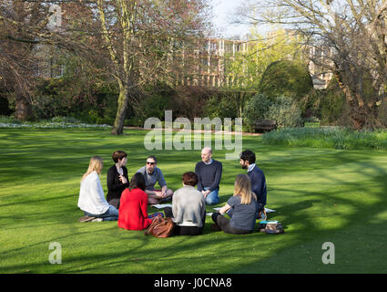University students studying outdoors in a study group, Sidney Sussex College, Cambridge University Cambridge UK Stock Photo
