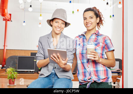 Two women with tablet computer as creative startup team Stock Photo