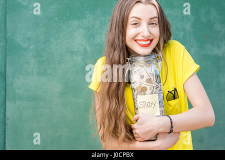 Woman holding a bottle full of money savings for study Stock Photo