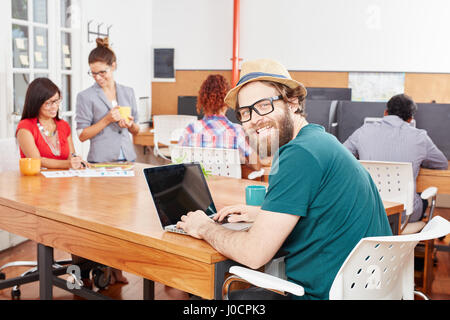 Nerd programmer with laptop in IT startup Stock Photo