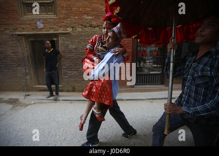 Kathmandu, Nepal. 12th Apr, 2017. A Nepalese devotee carries the Living Goddess Kumari to the bathing ritual ceremony of God Rato Machindranath in Lalitpur, Nepal on Wednesday, April 12, 2017. Credit: Skanda Gautam/ZUMA Wire/Alamy Live News Stock Photo