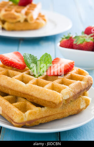 Waffles with strawberries on blue wood Stock Photo