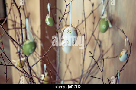 birch branches decorated with Easter eggs in white and green colors decorated with ribbons Stock Photo
