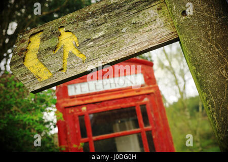 Rural village red BT phonebox beside a footpath sign in Cascob Powys Wales Stock Photo