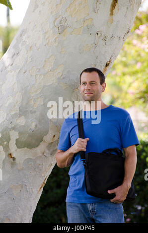 Adult man with a lap top bag across his shoulder. Business man or adult student concept. New beginnings to a fresh start. Stock Photo