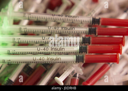 Insulin syringes on multicolored background out of focus Stock Photo