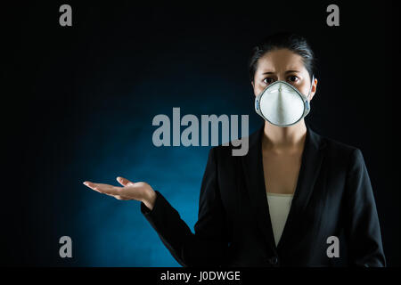 business woman showing presenting hand gesture wearing a face mask. Young multiracial Asian chinese female model Stock Photo