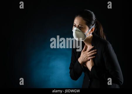 sickness business woman feel unwell wearing a face mask to deal with lung virus or pollution. mixed race asian chinese model Stock Photo