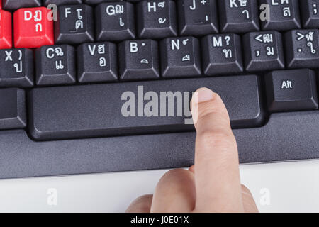 finger pushing space bar button on a keyboard of computer Stock Photo