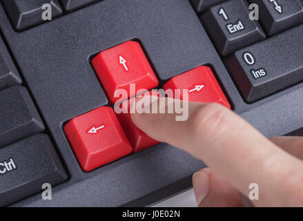 finger pushing arrow button on a keyboard computer Stock Photo