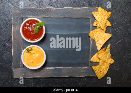 Mexican nacho with sauces and chalk board on black background, top view, copy space Stock Photo