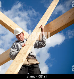 carpenter at work with wooden  roof construction Stock Photo